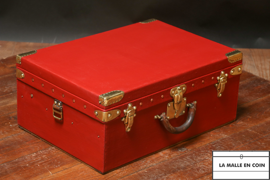 Red trunk-suitcase of the luxury brand Louis Vuitton