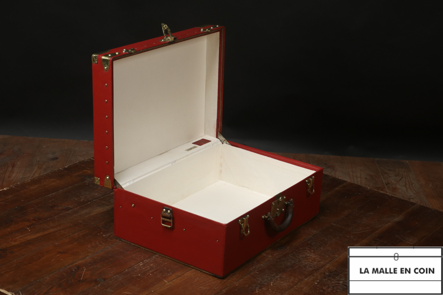 Red trunk-suitcase of the luxury brand Louis Vuitton